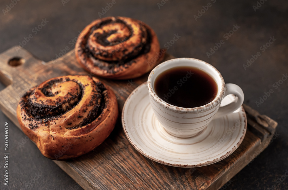 coffee and bun with poppy seeds on a stone background. breakfast concept coffee and bun with poppy seeds on a stone background. breakfast concept