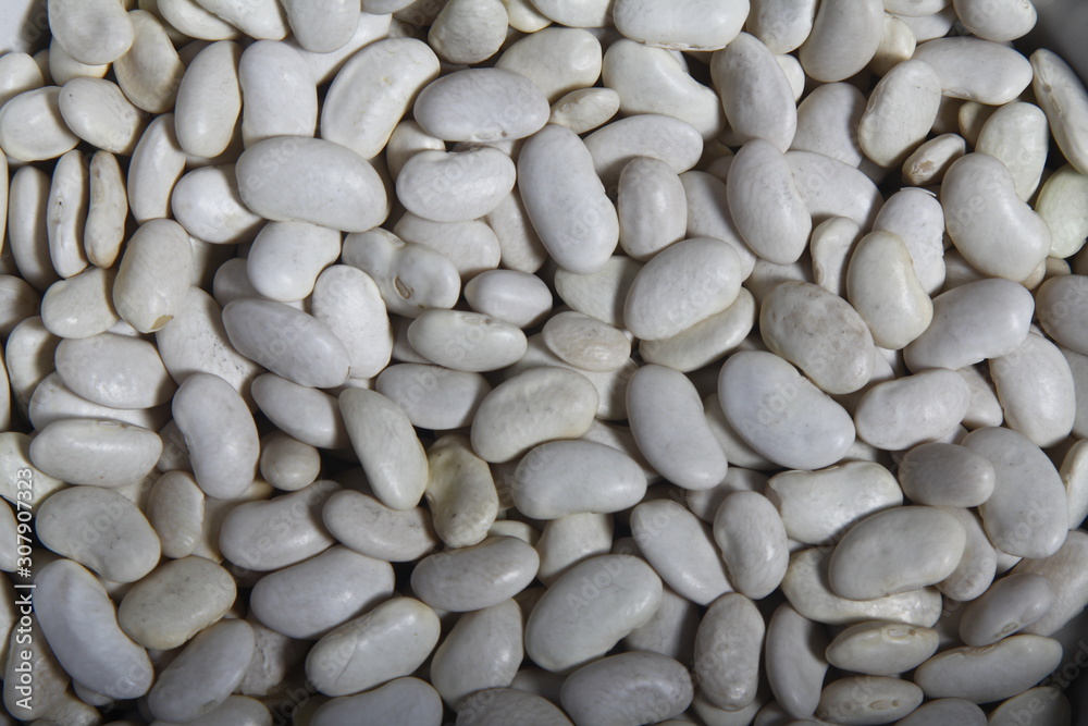 Close-up of lots of white beans, also called navy bean, haricot or pearl haricot in a grocery store