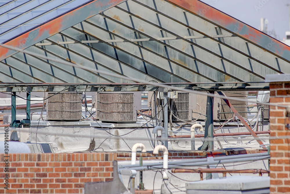 Rooftop infrastructure with HVAC units, piping with a glass and steel truss structure
