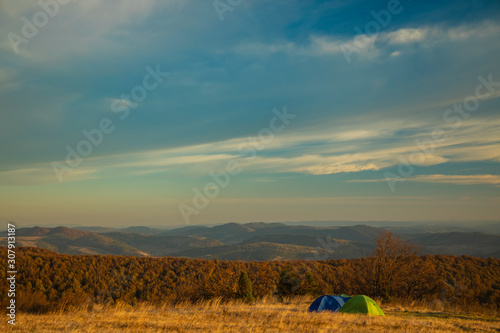 hiking life style landscape photography of tent in mountains in autumn time moody dramatic nature environment and cloudy sky background with empty copy space for your text 