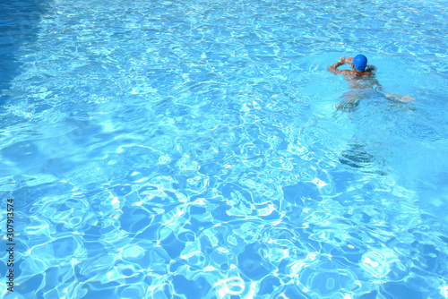 Man is Swimming in the Swimming Pool by Morning at Summer