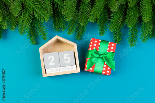 Top view of fir tree, wooden calendar and gift box on colorful background. The twenty fifth of December. Merry Christmas time with empty space for your design photo