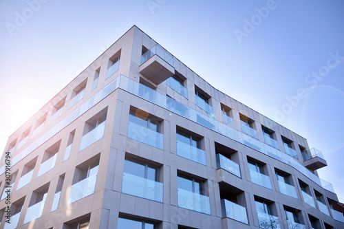 Modern apartment buildings on a sunny day with a blue sky. Facade of a modern apartment building. Glass surface with sunlight.