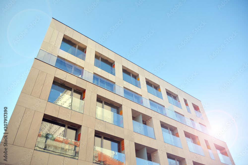 Modern apartment buildings on a sunny day with a blue sky. Facade of a modern apartment building. Glass surface with sunlight.