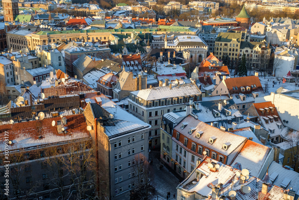 Panorama view of Riga Old Town, Latvia in winter day. Aerial view from St. Peter's cathedral on snowy roofs and medieval streets.