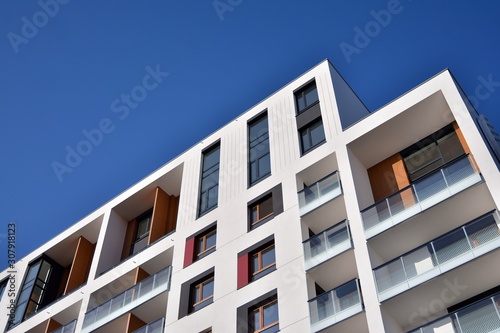 Modern apartment buildings on a sunny day with a blue sky. Facade of a modern apartment building. Glass surface with sunlight.