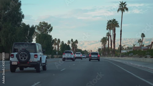 PALM DESERT, CALIFORNIA - FEBRUARY 2019: Cinematic view of cars driving on Portola Avenue during the evening photo