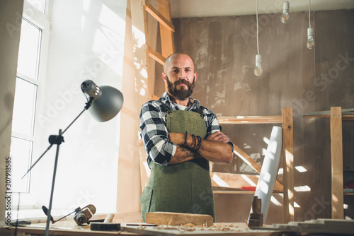 Portrait of a young male carpenter who works in his workshop.
