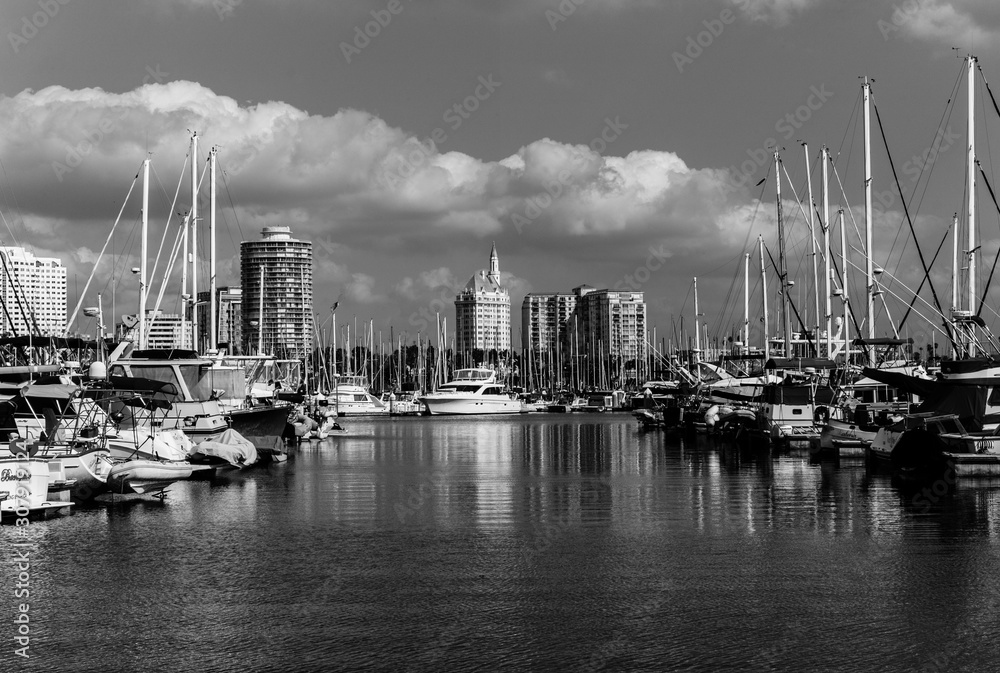Yachts in Long Beach marina with buildings in background.