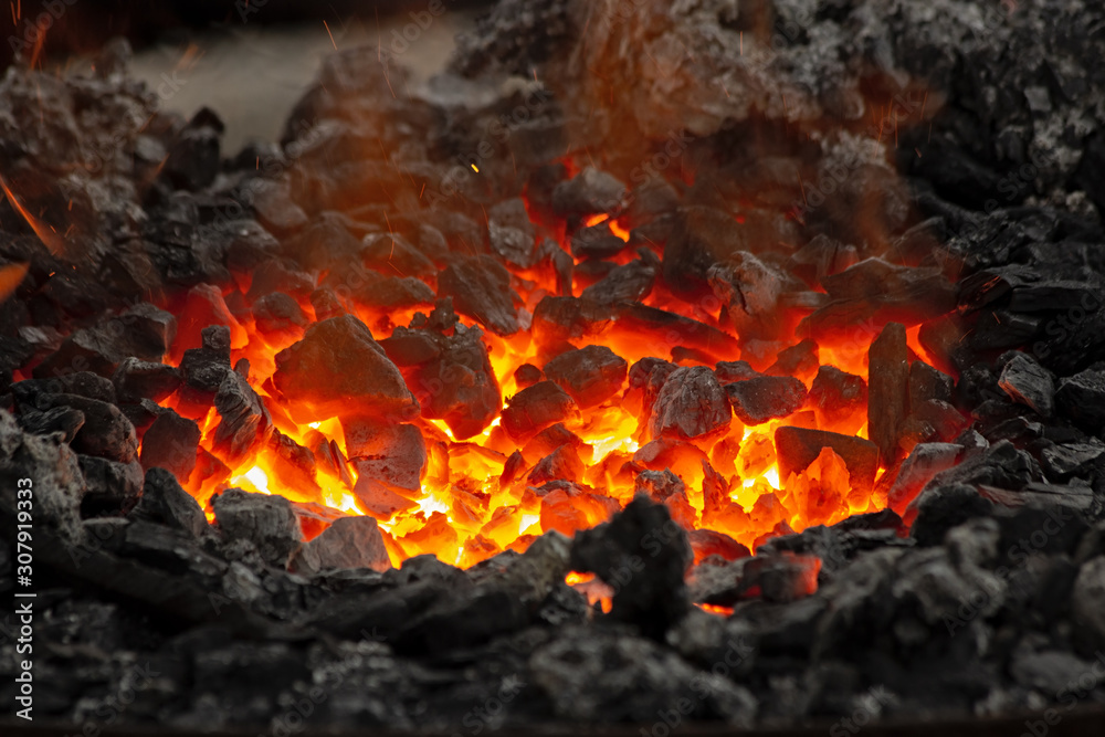 Flame and embers glow in a bonfire. Fire, heat, coal and ash with flying sparks. Flame and embers glow in a bonfire. Fire, heat, coal and ash with flying sparks.