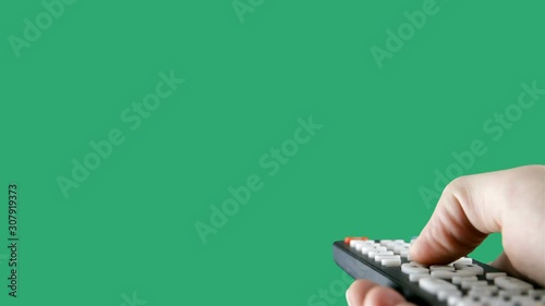 Hand using a remote control over a green screen background photo