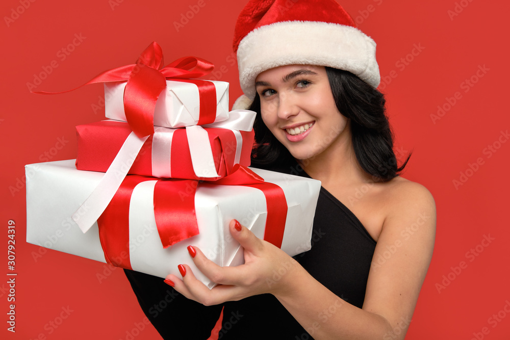 Pretty girl is excited holding several giftboxes of different sizes of white color with red ribbon. Pretty girl is excited holding several giftboxes of different sizes of white color with red ribbon.