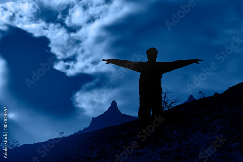 Young man is practicing yoga. Traveling in the mountains. Yoga concept. Meditating on sunrise mountain peak.