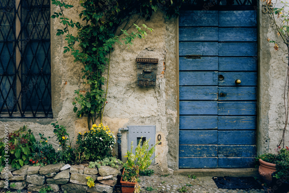 Facade of an old provincial house with shabby walls and a blue painted ...