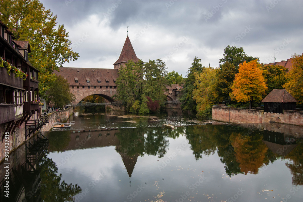 Obraz premium Hallertorbrücke, an old historical landmark, an arch bridge across Pegnitz river in Nuremberg, Germany.