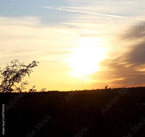The bright sun of the sunset over the country landscape.