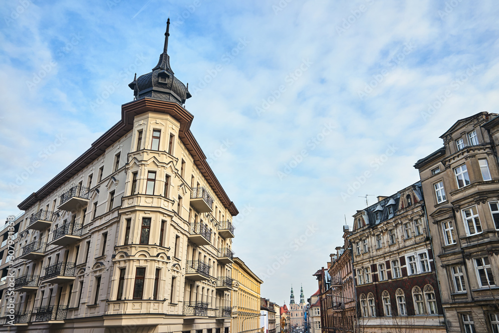 Street with historic tenement houses and church towers in Poznan..