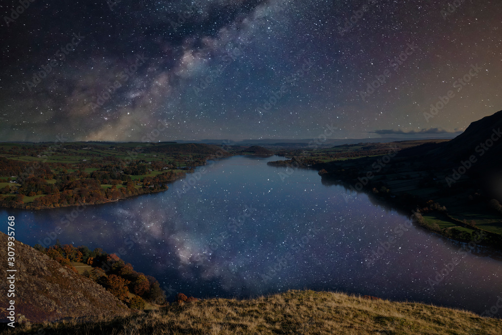 Beautiful epic digital composite landscape of Milky Way over Hallin Fell and Ullswater in Lake District