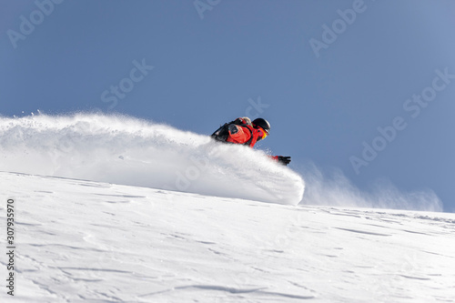 Snowboarder in orange clothing enjoying winter vacation.