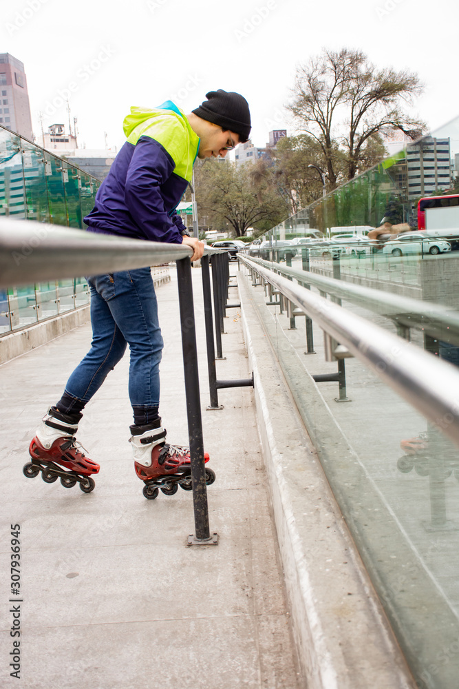 Man skating and performing in the street holding the handrail