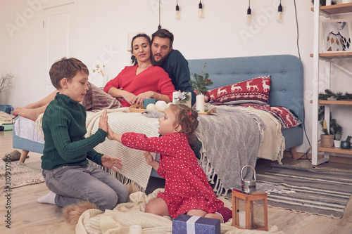 Little Boy Girl Having Fun Friendship Between Siblings Family Leisure Time In Living Room Children Sister And Brother Playing Drawing Together On Floor While Young Parents Relaxing At Home On Sofa Stock Little Boy Girl Having Fun Friendship Between Siblings Family Leisure Time In Living Room Children Sister And Brother Playing Drawing Together On Floor While Young Parents Relaxing At Home On Sofa Stock