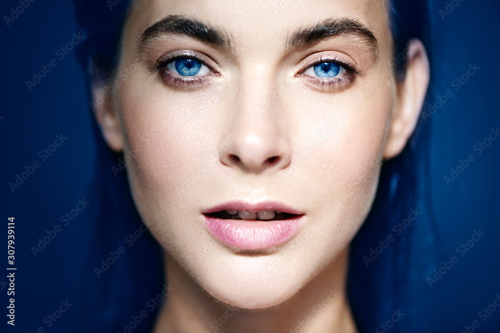 Portrait of beautiful blue-eyed woman on blue background. Portrait of beautiful blue-eyed woman on blue background.