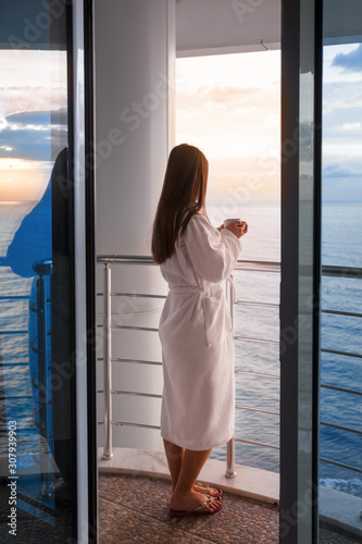 Woman drink coffee on hotels balcony on holiday rest.