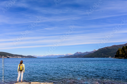 Landscape view of a young woman on the Nahuel Huapi lake coast against Andes mountains in Arrayanes National Park, Villa La Angostura, Patagonia, Argentina © Pedro Suarez