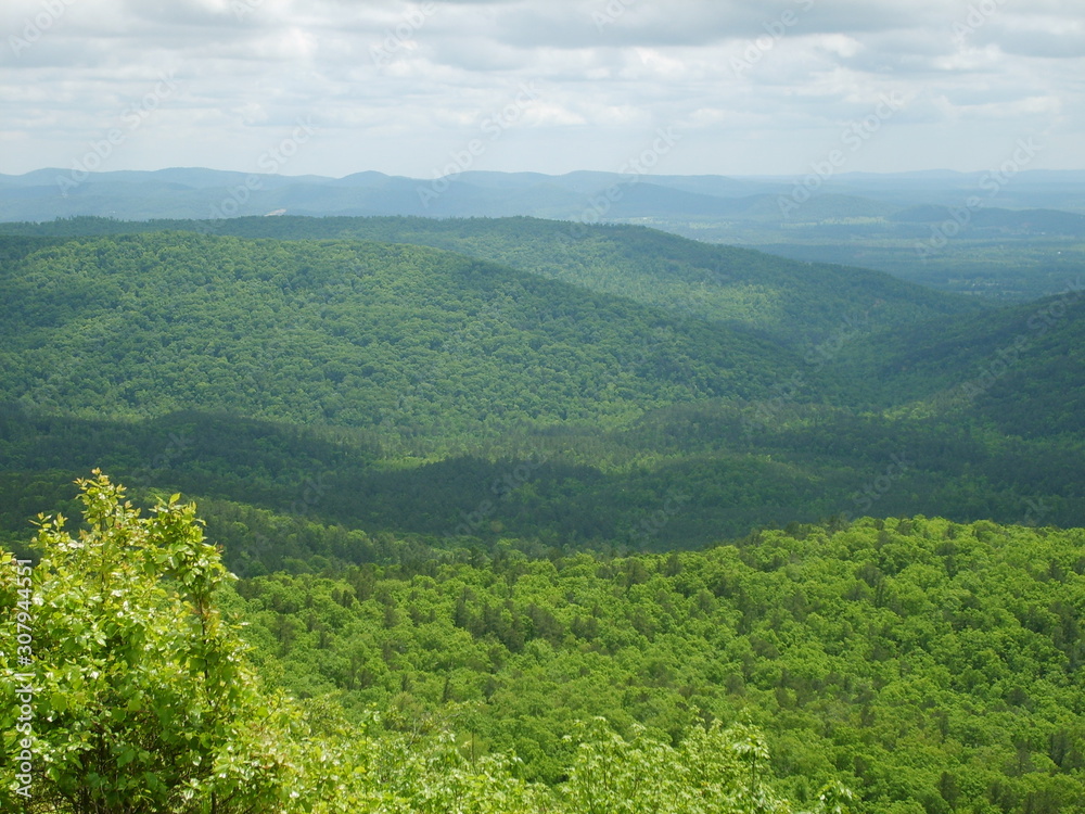 Aerial looking into a lush mountain valley in summer