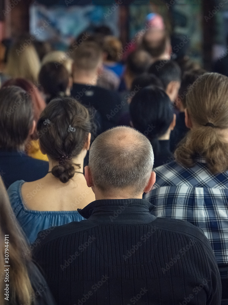Back view of the man with a bald head in a conference hall. Back view of the man with a bald head in a conference hall.
