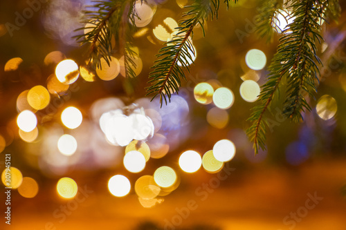 December Christmas decoration on Christmas tree bruches close up, blurred lights in the background / Christmas texture backdrop/ good wishes gift card/ space for text 3/8