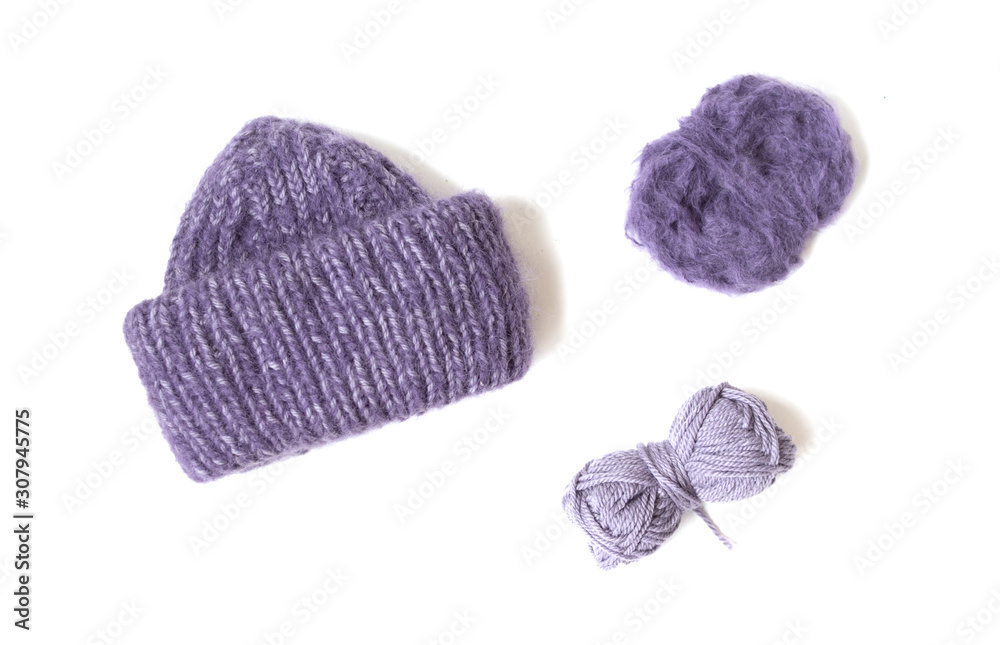 Fototapeta premium Purple hat and yarn balls on the white background. Knitted clothes. 