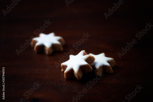 Christmas cookies (cinnamon stars) on dark background. Close up. 