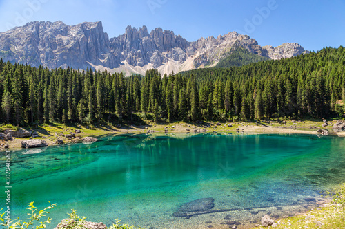 Lake Carezza with its turquoise water and in the background the Dolomites