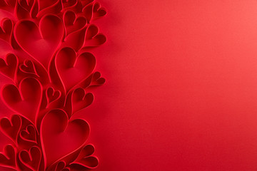 Red paper hearts on red paper background. Love and Valentine's day concept.