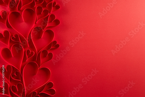 Red paper hearts on red paper background. Love and Valentine's day concept. photo