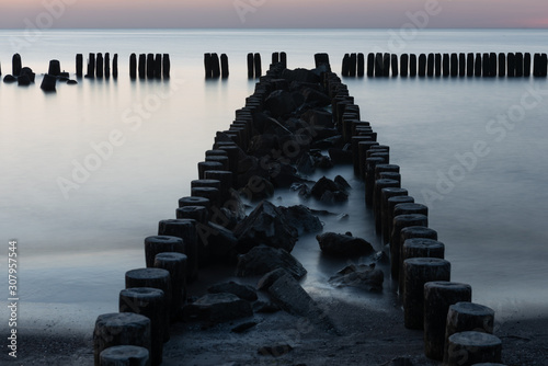 Wooden breakwater at sunset on the Baltic Sea photo