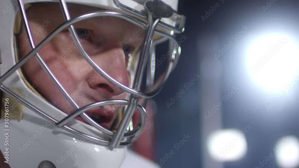 Extreme close up face of concentrated male ice hockey player wearing helmet and waiting for match to begin Extreme close up face of concentrated male ice hockey player wearing helmet and waiting for match to begin