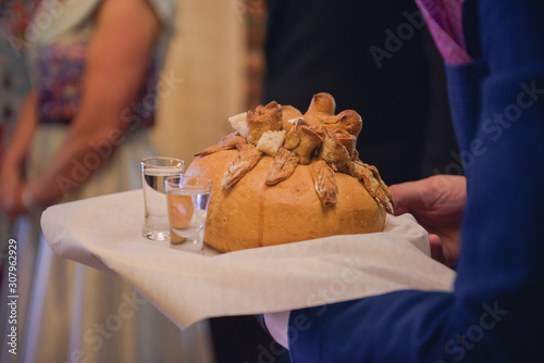 Traditional polish greeting the bride and groom by the parents with bread and salt. Vodka also in glasses