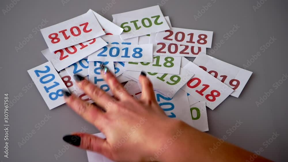 Picking out the new year's date from a pile of paper with written years, making room for 2020. Picking out the new year's date from a pile of paper with written years, making room for 2020.