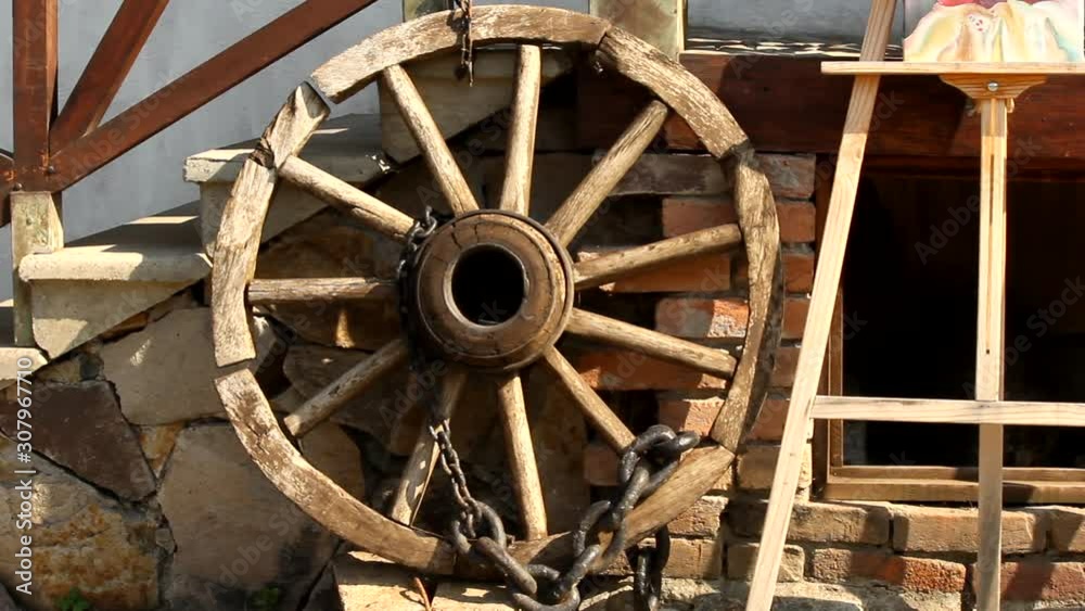 A Large Wooden Wheel And A Wooden Canvass Stand Laying By The Stone Stairs And Fireplace Outside Of A Home In Yuriy Gyumri, Armenia - Wide Pan Shot A Large Wooden Wheel And A Wooden Canvass Stand Laying By The Stone Stairs And Fireplace Outside Of A Home In Yuriy Gyumri, Armenia - Wide Pan Shot