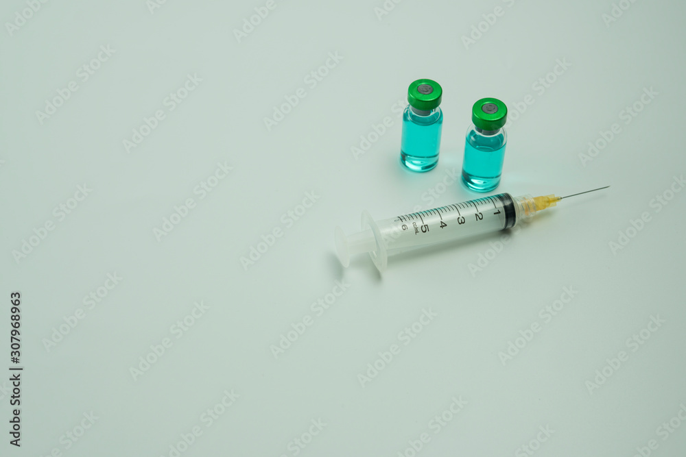 Selective focus of vial bottles with blue liquid and syringe isolated white background. Medical concept. Selective focus of vial bottles with blue liquid and syringe isolated white background. Medical concept.