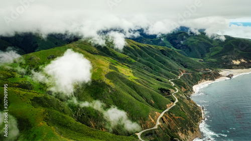 mountains with a road next to the ocean