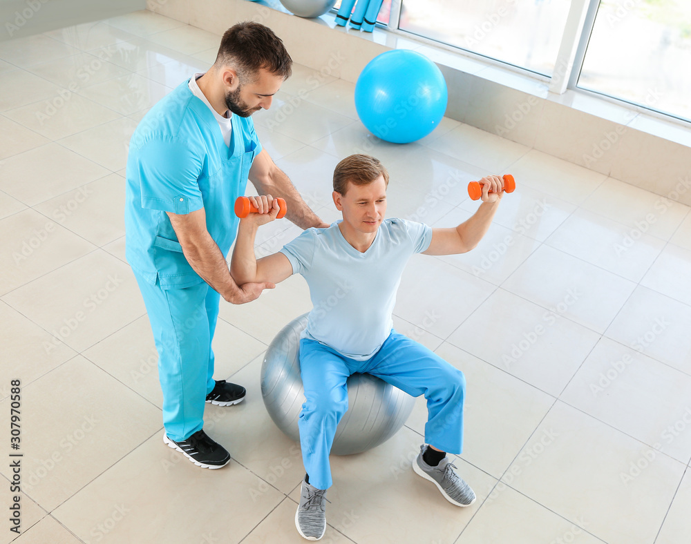 Physiotherapist working with male patient in rehabilitation center Physiotherapist working with male patient in rehabilitation center