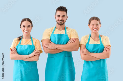 Team of janitors on color background