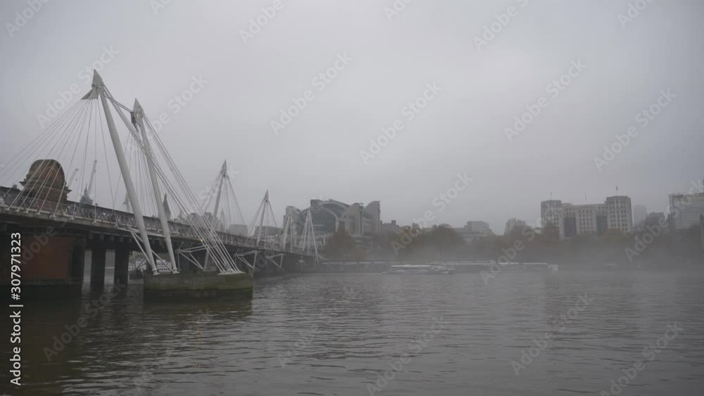 A pedestrian bridge over the Thames River in a fog. A pedestrian bridge over the Thames River in a fog.