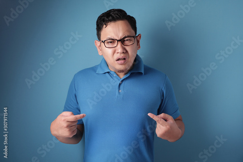 Asian Man Pointing Himself with Unhappy Expression as if he confused to be accused © airdone