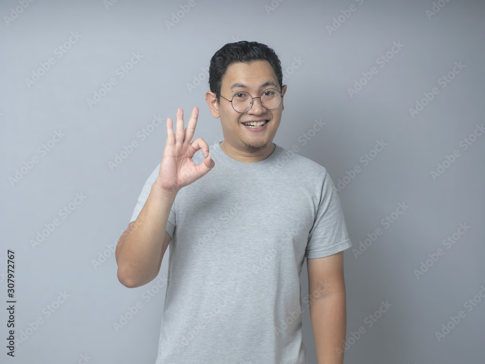 Young Man Smiling and Showing OK Sign gesture Young Man Smiling and Showing OK Sign gesture