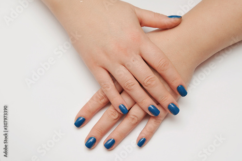 Female hand with trendy manicure in classic blue color. Color of the year 2020.