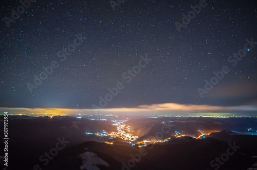 Night city in the fog in the mountains in autumn